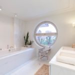 Bad mit Marmor Doppelwaschbecken und große Badewanne in weiß